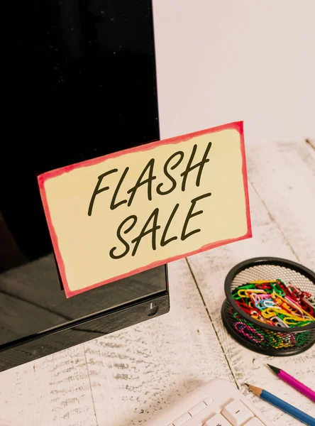Escribiendo nota mostrando Flash Sale. Foto comercial que muestra una venta de bienes a precios muy reducidos en un corto período Nota papel pegado a la pantalla del ordenador negro cerca del teclado y estacionario . — Foto de Stock