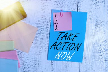 Take Action Now 'ı gösteren kavramsal el yazısı. İş fotoğrafçılığı resmi bir şey yap ya da uyumlu bir şey. Sorunlu bir hedef al. Kağıt levha, akıllı telefon, ahşap arka plan..