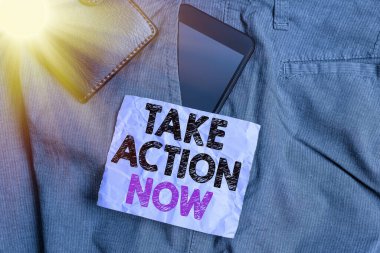 Kelime yazma metni Şimdi Harekete Geç. Resmi ya da uyumlu bir şey yapmak için iş konsepti sorun çıkaran akıllı telefon aygıtı ile hedefle pantolonunun ön cebinde cüzdan ve not kağıdı ile.