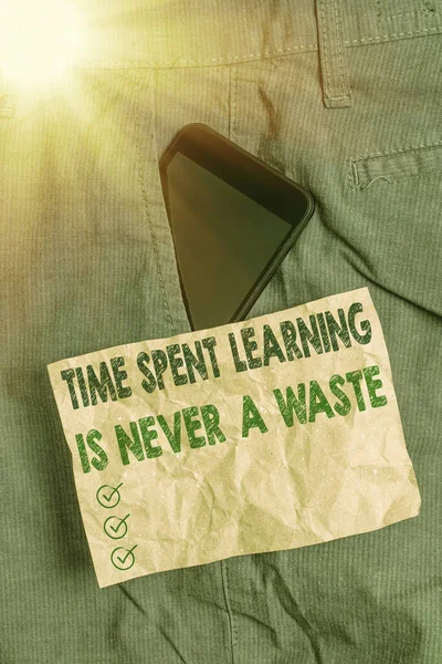 Escribir una nota que muestre que el tiempo dedicado al aprendizaje nunca es un desperdicio. La educación no tiene fin Sigue aprendiendo Dispositivo de Smartphone dentro de los pantalones Papel de bolsillo delantero . — Foto de Stock