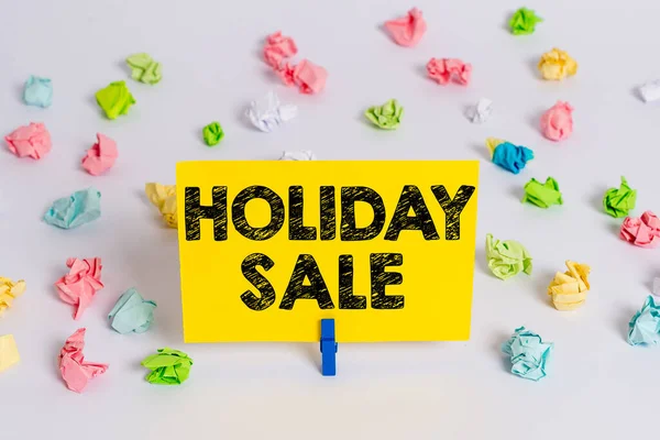 Texto de escritura Holiday Sale. Concepto que significa rebaja de los precios en las tiendas durante la temporada de festivales o festivos Papeles arrugados de colores recordatorio vacío Pasador de ropa de fondo de piso blanco . —  Fotos de Stock