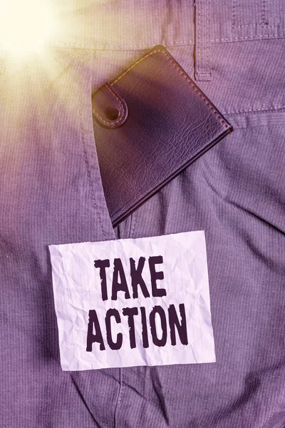 Text sign showing Take Action. Conceptual photo do something official or concerted to achieve aim with problem Small little wallet inside man trousers front pocket near notation paper.