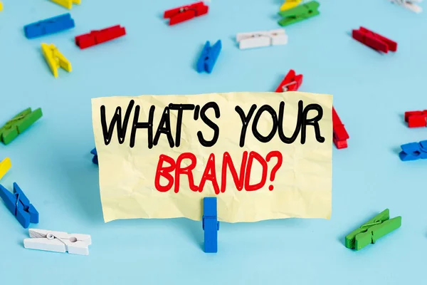 당신의 브랜드 질문을 보여 주는 문자 사인. 제품 로고에 대해 묻는 개념 사진 또는 당신이 무엇을 통신하는 색상 클럭 종이빈 푸른 층 배경 사무실 핀을 연상. — 스톡 사진