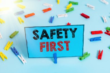 Önce Güvenlik 'i gösteren bir not yazıyorum. İş fotoğrafçılığı derdi ki, en önemli şey güvende olmaktır. Renkli çamaşır iğnesi kağıtları boş mavi zemin ofisini hatırlatır..