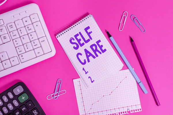 Sinal de texto mostrando Self Care. Prática de fotografia conceitual de tomar medidas para preservar ou melhorar a própria saúde Equipamentos de escrita e materiais informáticos colocados acima da mesa plana colorida . — Fotografia de Stock