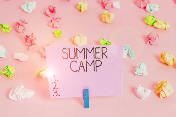 Handschrift tekst schrijven Summer Camp. Concept betekent begeleide programma voor kinderen uitgevoerd tijdens de zomer Gekleurde verfrommelde papieren lege herinnering roze vloer achtergrond wasknijper. — Stockfoto