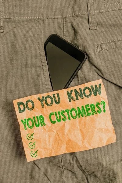 Writing note showing Do You Know Your Customers question. Business photo showcasing asking to identify a customers is nature Smartphone device inside trousers front pocket note paper. — Stock Photo, Image
