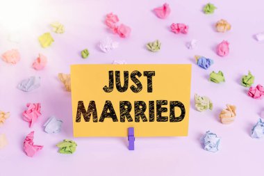 El yazısı yeni evlenmiş. Kavram, yakın zamanda evlenmiş ya da evlilikten geçmiş biri anlamına gelir. Renkli buruşuk kağıtlar boş hatırlatıcı beyaz zemin çamaşır mandalı..