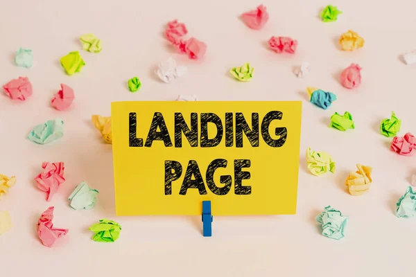 Tekst pisma Landing Page. Koncepcja oznacza stronę internetową, do której użytkownik dociera po kliknięciu hiperłącza Kolorowe pogniecione papiery puste przypomnienie białe podłogi tło szpilka do ubrań. — Zdjęcie stockowe