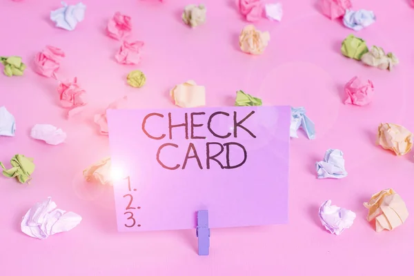 Kézírás szövegírás csekk kártya. Koncepció jelentése lehetővé teszi a számlatulajdonos számára, hogy hozzáférjen a számláján lévő pénzeszközökhöz Színes gyűrött papírok üres emlékeztető rózsaszín padló háttér ruhaszárító. — Stock Fotó