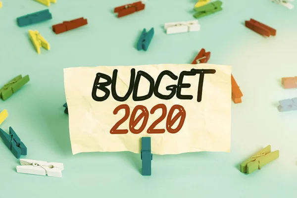 Signo de texto que muestra Presupuesto 2020. Foto conceptual estimación de ingresos y gastos para el próximo año o en curso Papeles de pinza de ropa de colores recordatorio vacío azul piso fondo oficina pin . —  Fotos de Stock