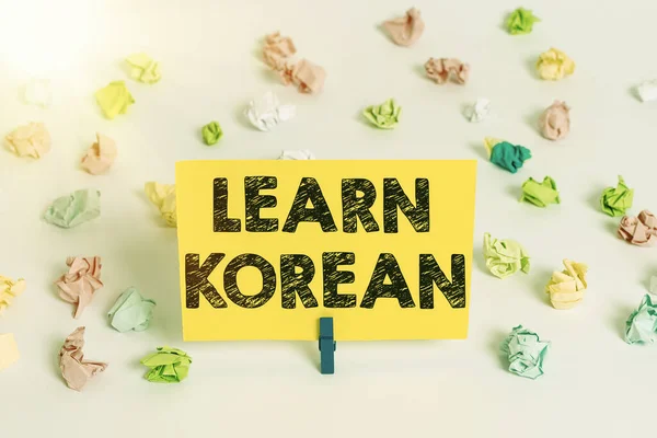 El yazısı yazısıyla Korece öğren. Kavram, Korece konuşma ve yazmada bilgi ve beceri kazanma anlamına gelir. Renkli buruşmuş kağıtlar boş hatırlatıcı beyaz zemin çamaşır mandalı. — Stok fotoğraf