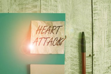 Kalp krizi belirtileri var. Ani koroner trombozun kavramsal fotoğrafı ölüm ile sonuçlanır. Kırışıklık kağıdı ve karton artı ahşap arka planda sabit duruyor..