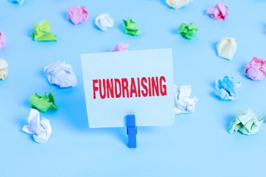 Bağış topladığını gösteren bir mesaj. Yardım derneği için maddi destek arayan kavramsal fotoğraf ya da renkli buruşuk kağıtların boş hatırlatıcı mavi zemin çamaşır mandalına sebep olmaya çalışan.