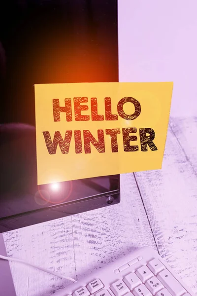 Текст письма Hello Winter. Концепция бизнеса на самый холодный сезон года в полярных и умеренных зонах Бумага для заметок приклеена к экрану монитора черного компьютера возле белой клавиатуры . — стоковое фото