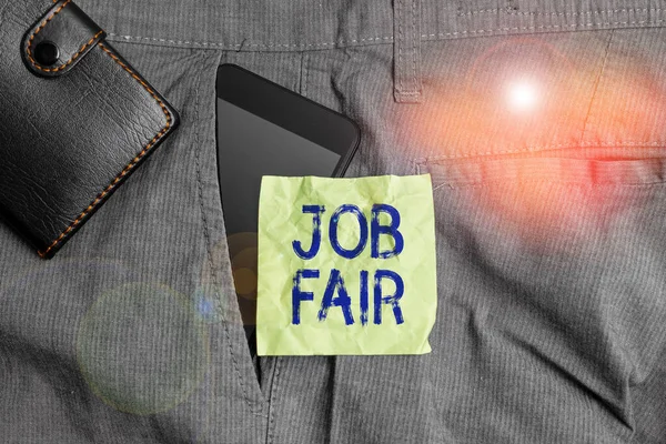 Handwriting text writing Job Fair. Concept meaning event in which employers recruiters give information to employees Smartphone device inside trousers front pocket with wallet and note paper.