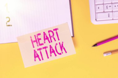 Kalp krizi belirtileri var. Ölümle sonuçlanan koroner trombozun kavramsal fotoğrafı. Sarı masada fotokopi alanı olan boş turuncu kağıt..