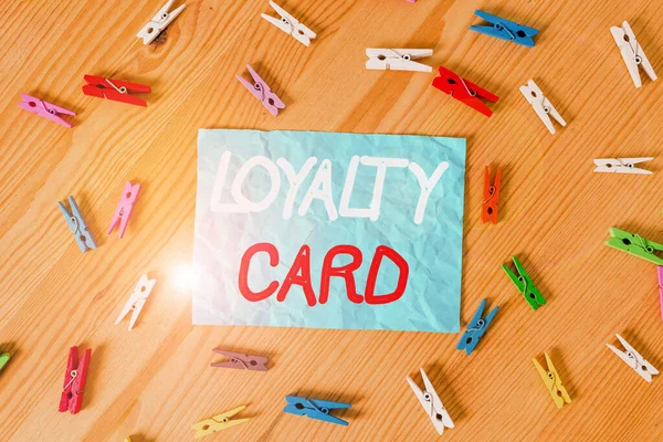 Text sign showing Loyalty Card. Conceptual photo used to record credit points awarded for money spent in store Colored clothespin papers empty reminder wooden floor background office.