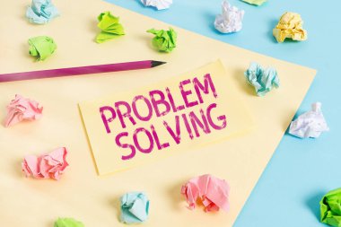 El yazısı problem çözme metni. Zor ya da karmaşık sorunlara çözüm bulma süreci kavramını kavra Renkli buruşmuş kağıtlar boş hatırlatıcı mavi arka plan mandalı.