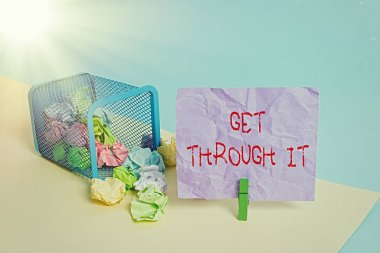 Get Through It 'i gösteren bir not yazıyorum. İş fotoğraflarının sergilenmesi, çöp tenekesi buruşmuş kağıt çamaşır mandalı ofis malzemelerini geçirmeyi veya hayatta kalmayı başaran birini teşvik ediyor..