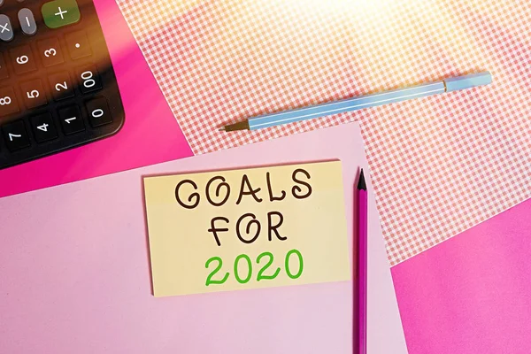 2020 için hedefleri gösteren bir not yazılıyor. İş fotoğraflarında gösteriler, hırs, çaba, amaç ya da istenen sonuç olarak masaya yerleştirilen donanım ve notlar gösteriliyor. — Stok fotoğraf