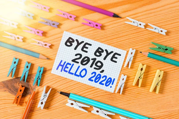 Концептуальний рукописний текст, що показує Bye Bye 2020 Hello 2020: діловий фототекст, що прощався з минулим роком і вітає ще одного кольорового потовченого паперу з дерев'яним фоновим покриттям.. — стокове фото