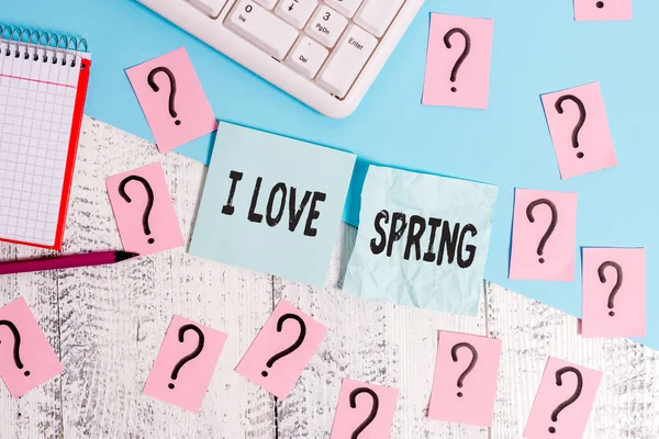 Writing note showing I Love Spring. Business photo showcasing telling why having a strong affection to this season Writing tools and scribbled paper on top of the wooden table.