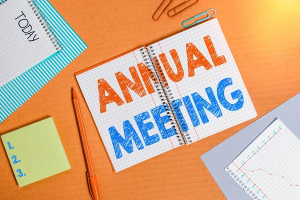 Word writing text Annual Meeting. Business concept for yearly meeting of the general membership of an organization Striped paperboard notebook cardboard office study supplies chart paper.