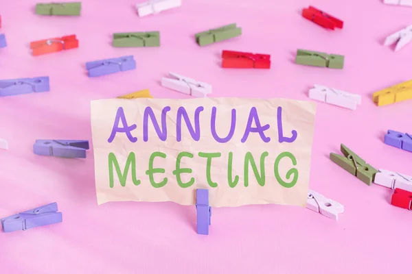 显示年度会议的文字签名。一个组织的会员大会彩色服装别针纸空提醒粉红地板背景办公室别针. — 图库照片