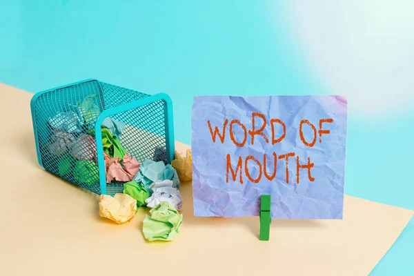 Writing note showing Word Of Mouth. Business photo showcasing information that is transmitted without being written down Trash bin crumpled paper clothespin reminder office supplies.