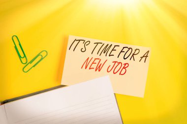 Yeni bir iş için zaman olduğunu gösteren not yazılıyor. İş fotoğrafı gösterimi düzenli bir iş imkanı sunuyor. Sarı masada fotokopi alanı olan boş turuncu kağıt..