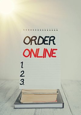 Düzen Online 'ı gösteren kavramsal el yazısı. İnternet üzerinden ürün ya da hizmet satın almanın iş fotoğrafı etkinliği rafa kaldırılmış kitap sarmalı ahşap masa üzerine not defteri.