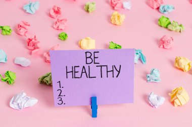 El yazısı. Sağlıklı ol. Güçlü ve bedensel veya zihinsel hastalıklardan tamamen uzak olmak anlamına geliyor. Renkli buruşuk kağıtlar. Boş hatırlatıcı, pembe zemin çamaşır mandalı..