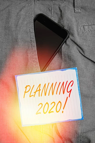 显示2020年规划的概念手写体明年为智能电话装置在裤子前边袖珍便笺中的应用制定计划的商业照片文字过程. — 图库照片