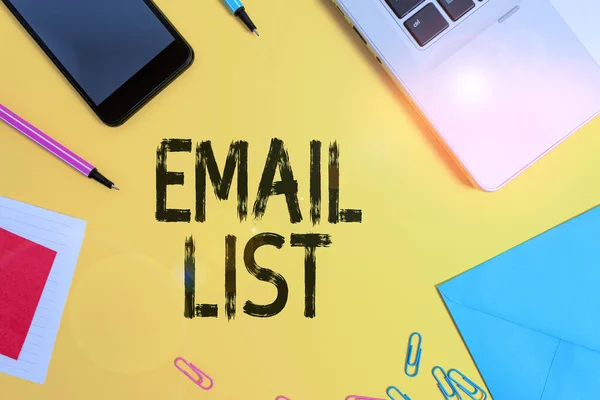 Conceptual hand writing showing Email List. Business photo text widespread distribution of information to many Internet users Laptop smartphone notepad markers sheet note clips colored back.