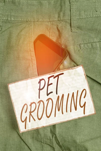 Sinal de texto mostrando Pet Grooming. Foto conceitual cuidados higiênicos e melhorar a aparência dos animais de estimação dispositivo Smartphone dentro de calças de trabalho formais bolso frontal perto de papel nota . — Fotografia de Stock