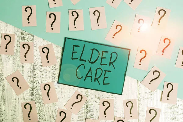 Text sign showing Elder Care. Conceptual photo the care of older showing who need help with medical problems Scribbled and crumbling papers with thick cardboard above wooden table.