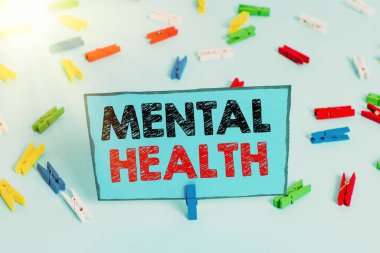 Akıl Sağlığını gösteren bir not yazıyorum. İş fotoğraflarının gösteriminin psikolojik durumu göz önüne alındığında renkli çamaşır iğnesi kağıtları boş mavi zemin ofisini anımsatıyor..