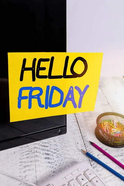 Text sign showing Hello Friday. Conceptual photo used to express happiness from beginning of fresh week Note paper taped to black computer screen near keyboard and stationary.