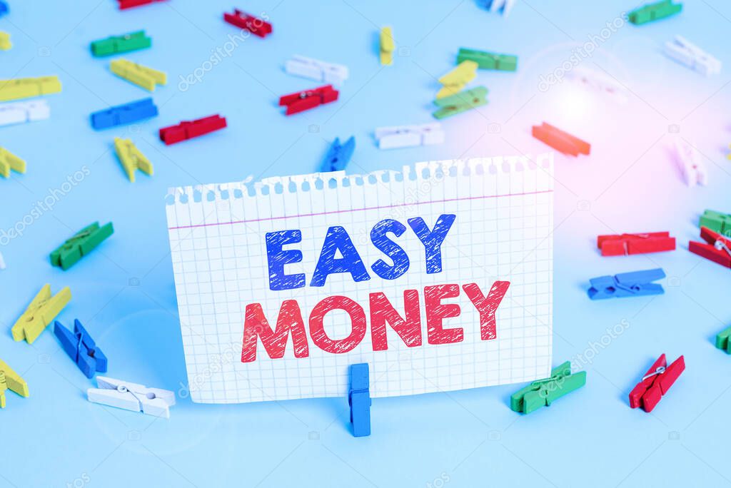 Writing note showing Easy Money. Business photo showcasing money that is easily have and sometimes dishonestly earned Colored clothespin papers empty reminder blue floor officepin.
