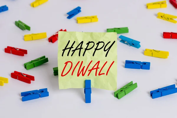 Un biglietto che mostra Happy Diwali. Business photo vetrina festival di luci che celebrato da milioni di indù colorati cartine clothespin vuoto promemoria pavimento bianco fondo ufficio . — Foto Stock