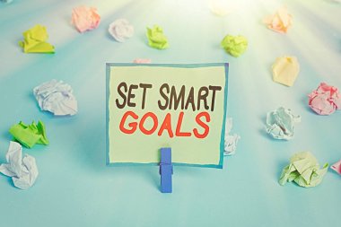 Akıllı Hedefleri Gösteren Kavramsal el yazısı. İş fotoğrafı gösterimi hedeflerin ayarlanmasında rehberlik edecek kriterler veriyor Renkli buruşuk kağıtlar boş hatırlatıcı mavi zemin çamaşır mandalı.