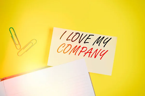 写便条，表明我爱我的公司。商业照片展示说明了为什么羡慕他们的工作和工作场所- -黄色桌子上放有复制空间的空橙色纸. — 图库照片
