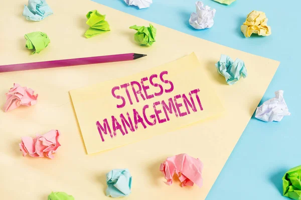 Handwriting text writing Stress Management. Concept meaning method of limiting stress and its effects by learning ways Colored crumpled papers empty reminder blue yellow background clothespin.