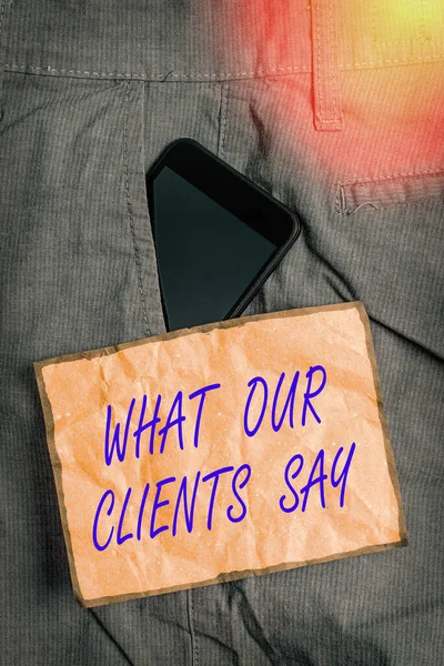 Conceptual hand writing showing What Our Clients Say. Business photo showcasing testimonials or feedback of aclient about the product Smartphone device inside trousers front pocket note paper.