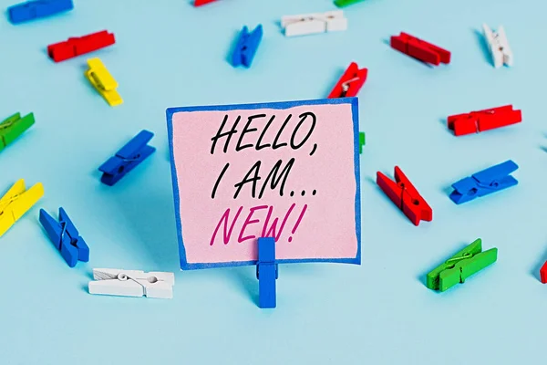 Texto de escritura de palabras Hello I Am New. Concepto de negocio para el saludo usado o comenzar la conversación telefónica Papeles de pinza de ropa de colores recordatorio vacío azul piso fondo oficina pin . — Foto de Stock