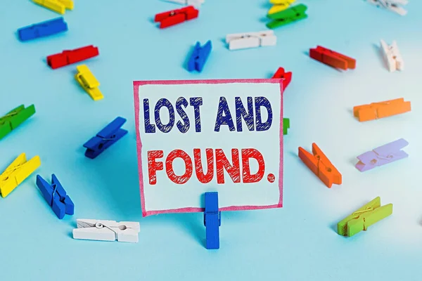 Signe texte montrant Lost And Found. Photo conceptuelle un endroit où les objets perdus sont stockés jusqu'à ce qu'ils récupèrent les papiers de pince à linge colorés rappel vide fond bleu épingle de bureau . — Photo