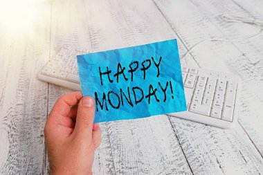 Kelime yazma metni Mutlu Pazartesi. Bu gösteri sırasına göre, elinde renkli, kare şeklindeki kağıt, klavye ahşap zemin tutan yeni hafta erkeğine dileklerini sunmak için iş konsepti..