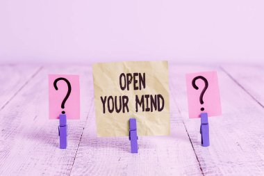 Zihnini Aç 'ı gösteren mesaj işareti. Farklı fikirleri anlayabilmek için kavramsal fotoğraf ya da düşünme şekillerini Tahta masaya yerleştirilmiş ataçlarla karalanmış ve parçalanmış kağıtlar.