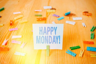 Mutlu Pazartesi 'yi gösteren bir not yazıyorum. İş fotoğraflarının sergilenmesi, bu gösteri sırasına göre ona harika bir yeni hafta dileklerini sunuyor. Renkli çamaşır iğnesi kağıtları boş ahşap zemin ofisini hatırlatıyor..